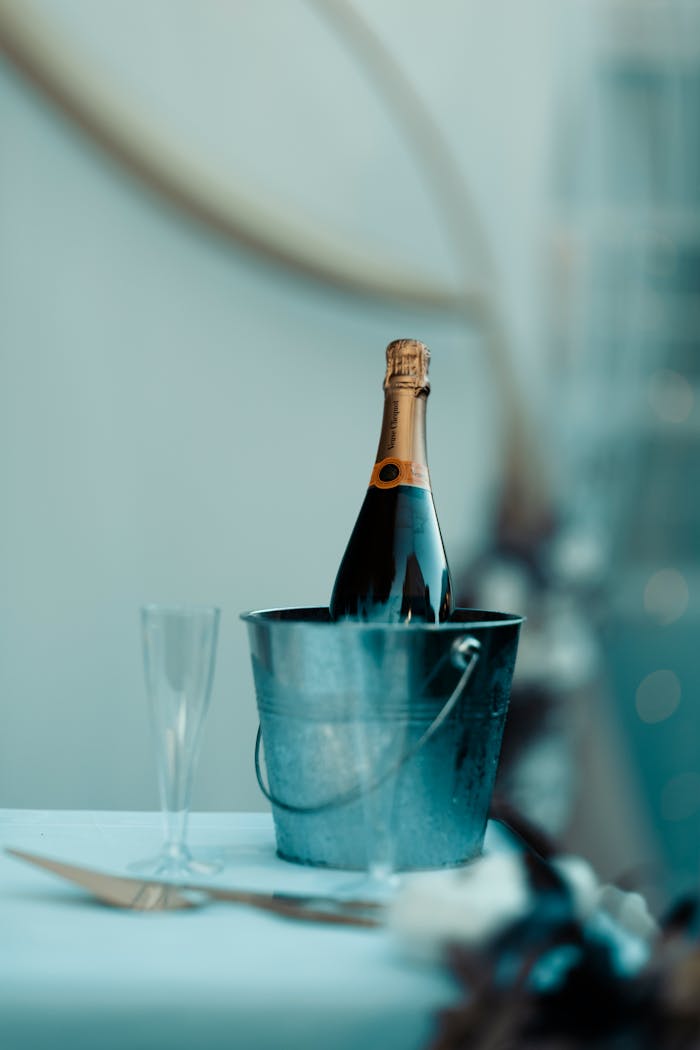 Champagne bottle chilling in an ice bucket with glass, perfect for celebrations.